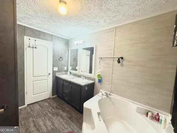 a bathroom with a tub sink and mirror