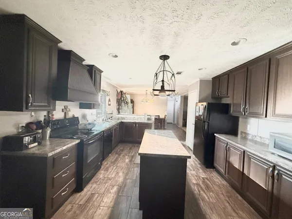 a kitchen with stainless steel appliances kitchen island granite countertop a sink and cabinets