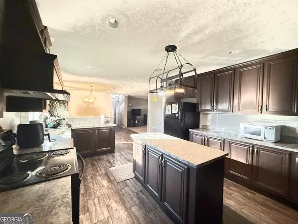 a kitchen with kitchen island granite countertop a sink cabinets and stainless steel appliances