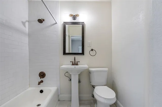 a bathroom with a toilet a sink and mirror