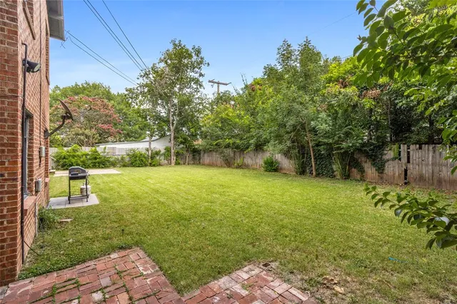 a view of a backyard with table and chairs and potted plants
