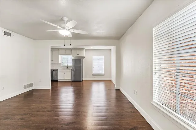 a view of a kitchen with wooden floor and a window