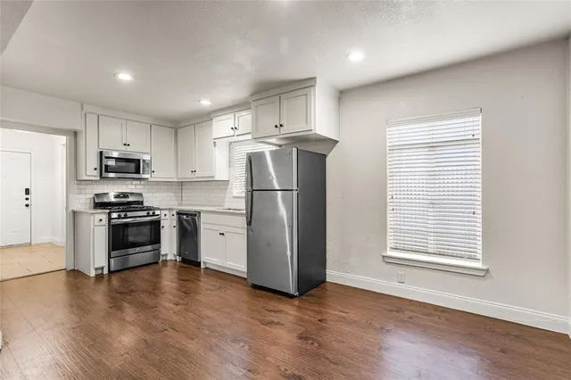 a kitchen with stainless steel appliances a refrigerator sink and microwave