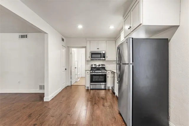 a kitchen with stainless steel appliances a refrigerator and a stove top oven