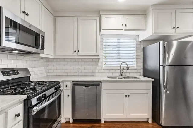 a kitchen with stainless steel appliances granite countertop a stove a refrigerator and a microwave