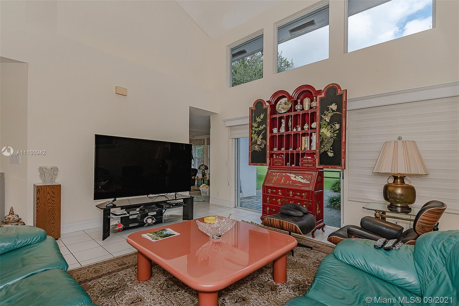 2295 Northwest 53rd Street Boca Raton, FL 33496 - Photo 2 of 25 a living room with furniture and a flat screen tv