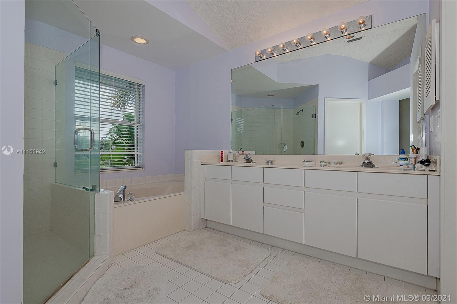 2295 Northwest 53rd Street Boca Raton, FL 33496 - Photo 13 of 25 a bathroom with a double vanity sink a mirror and a bathtub