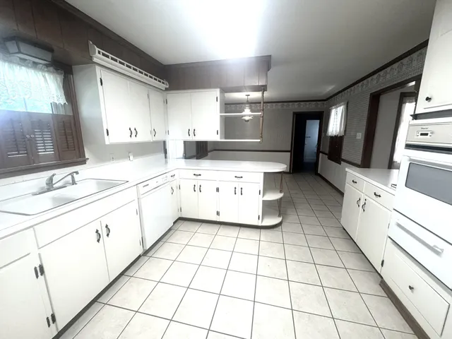 a kitchen with a sink a stove cabinets and counter space