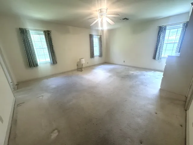 a spacious bedroom with a bed and a flat screen tv