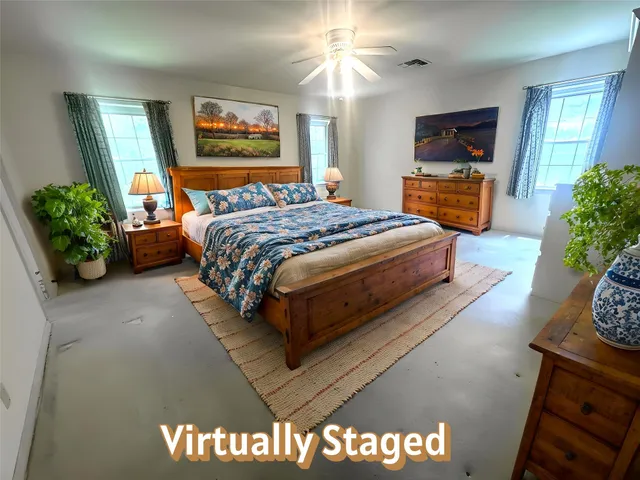 en empty room with windows and ceiling fan