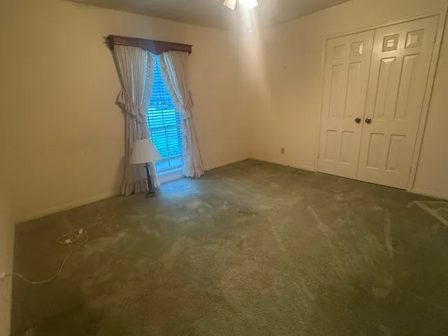 a view of an empty room and chandelier fan