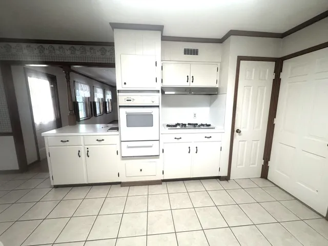 a kitchen with white cabinets and white appliances