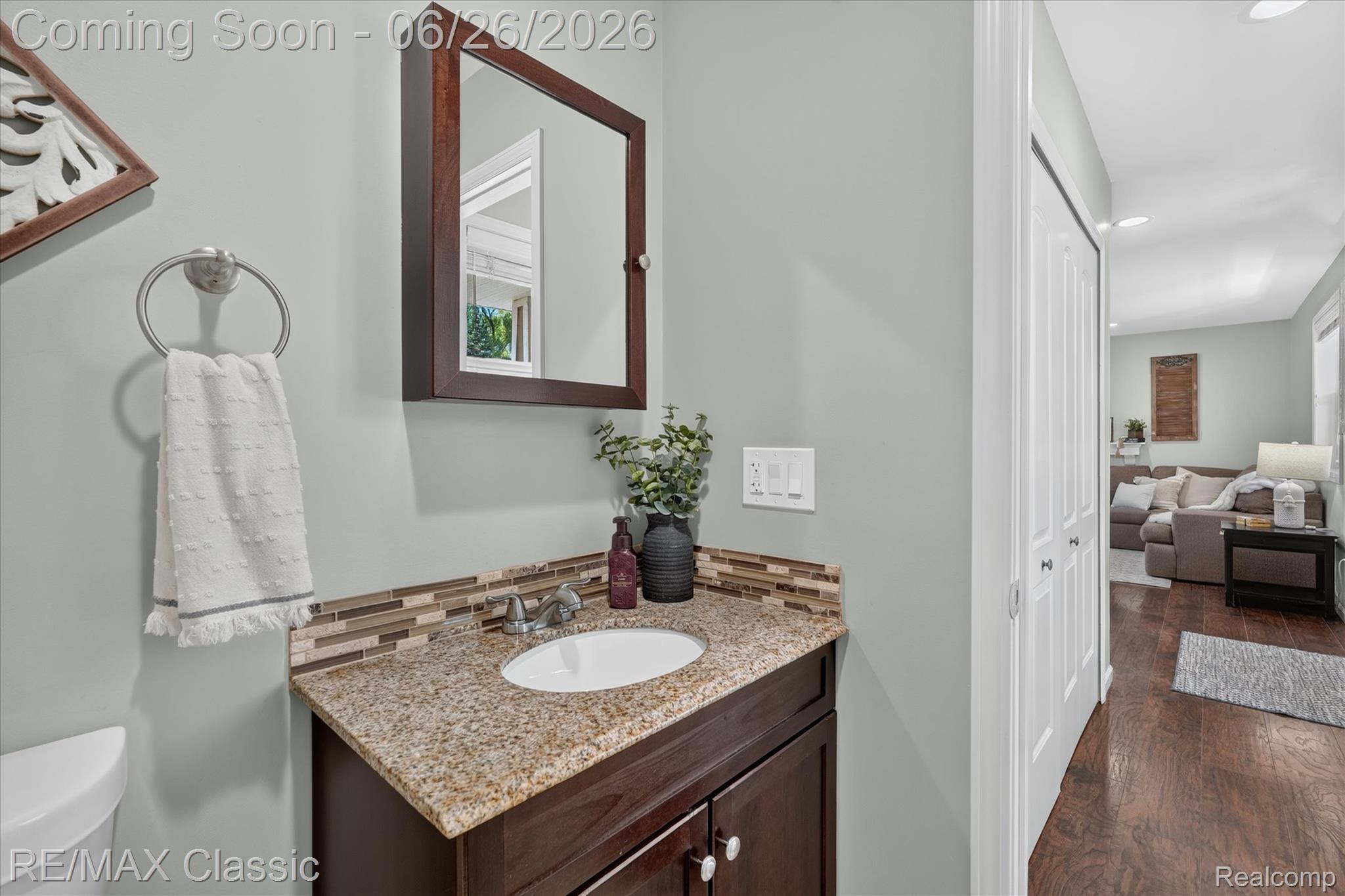 3205 North Milford Road Highland, MI 48357 - Photo 31 of 53 Bathroom vanity featuring a granite countertop with an undermount sink, a tiled backsplash, and a medicine cabinet with a wood frame