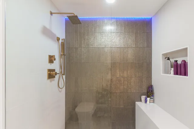 a bedroom with a bed a dresser next to a window