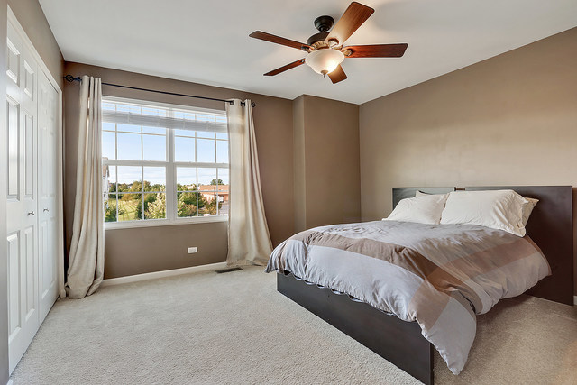 2816 Church Road Aurora, IL 60502 - Photo 14 of 20 a spacious bedroom with a large bed and a chandelier fan