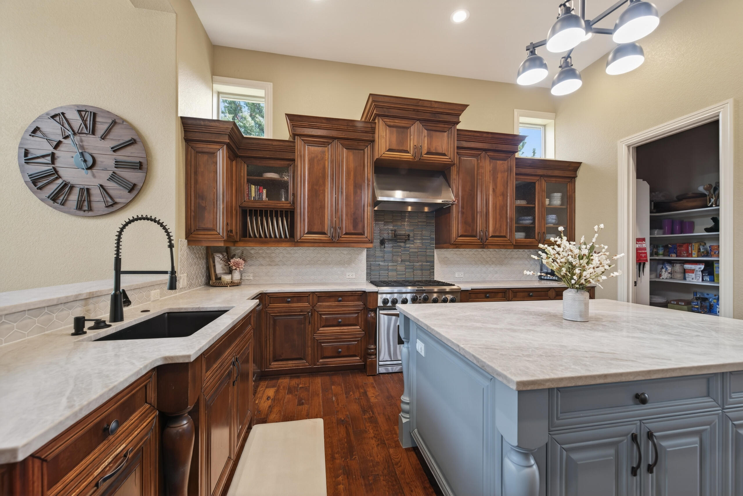 9009 Merlin Drive Redmond, OR 97756 - Photo 16 of 98 a kitchen with stainless steel appliances granite countertop a sink a stove and a wooden floors