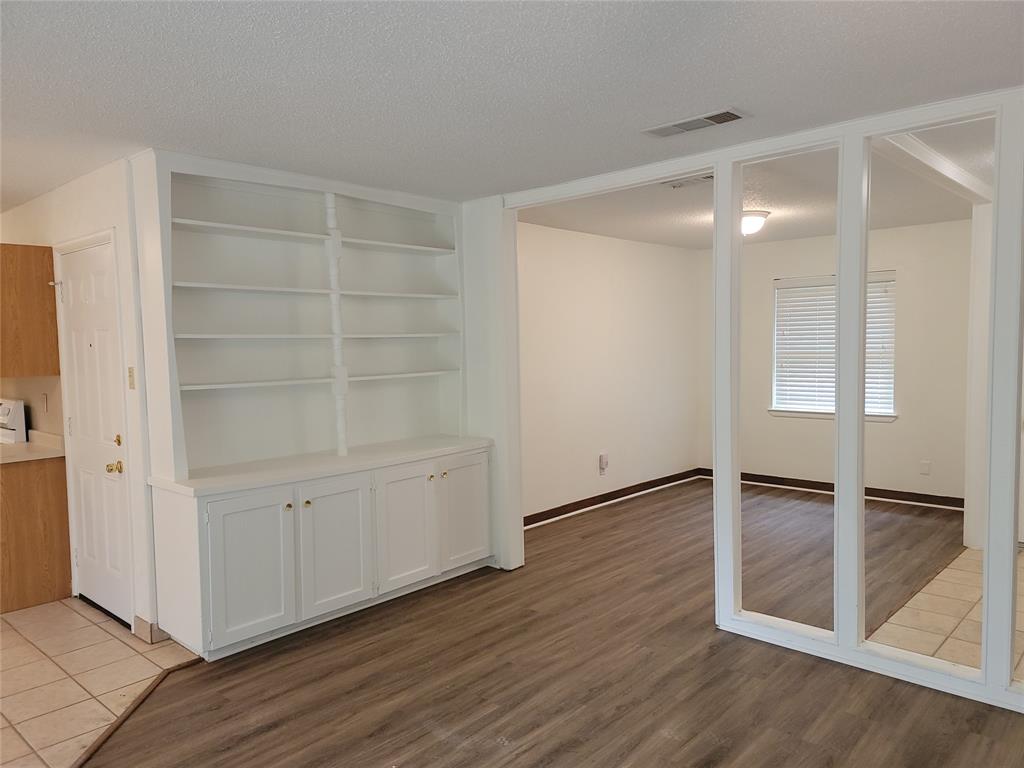 1000 Springdale Road Bedford, TX 76021 - Photo 2 of 36 Enter into the great room, connecting the living room and dining areas. Luxury vinyl plank and tile flooring throughout--NO CARPET. This built-in shelving unit is ready for your own decor!