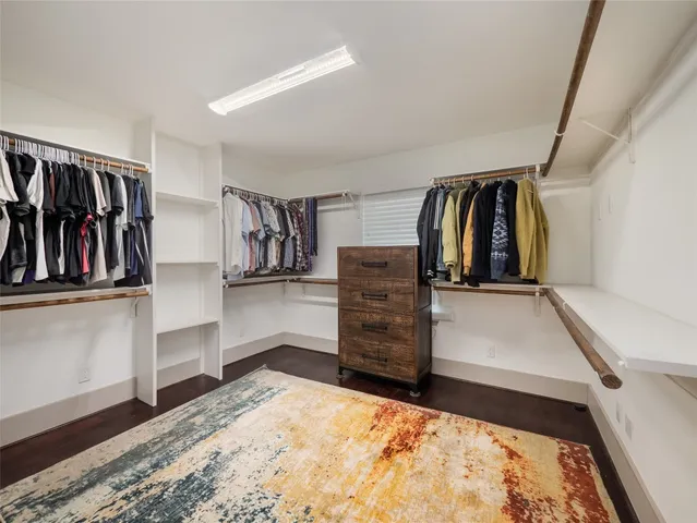 a view of walk in closet with clothes and shoes