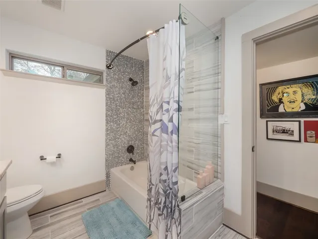 a bathroom with a bathtub a toilet and a shower