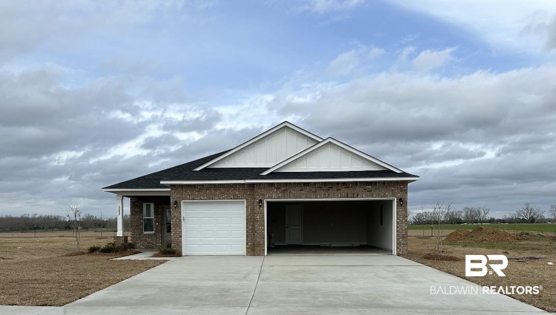 View of front of home featuring roof with shingles, brick siding, and concrete driveway