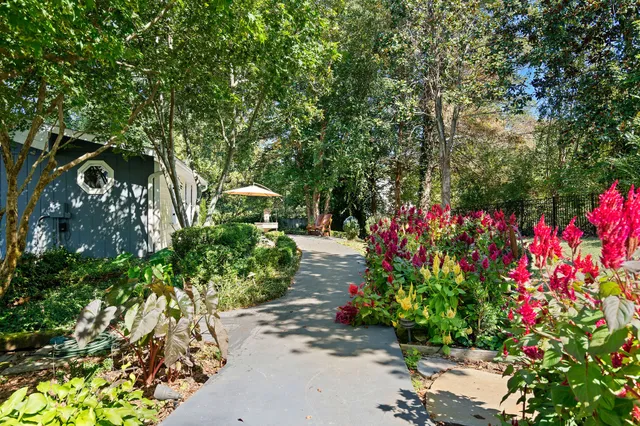 a view of house with backyard and a slide