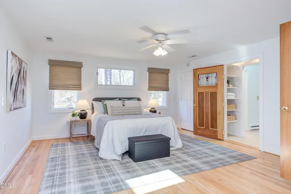 a bedroom with a bed and wooden floor
