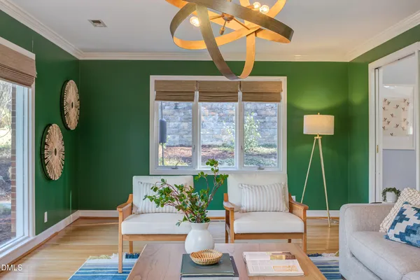a view of a dining room with furniture a chandelier and wooden floor