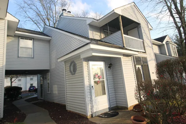 a view of a house with a yard and large tree