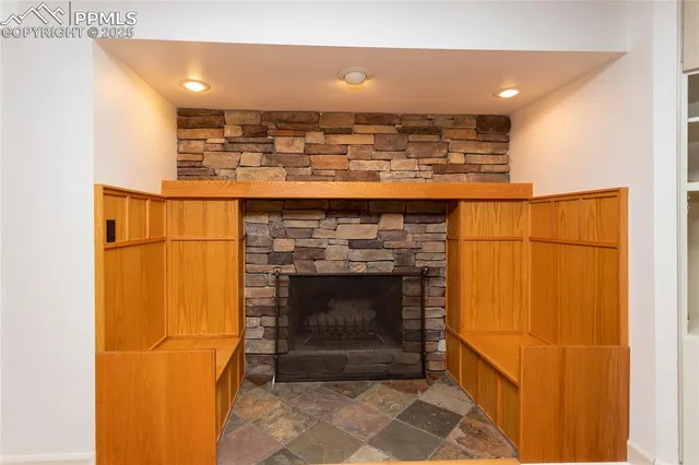 a living room with a fireplace and a ceiling fan