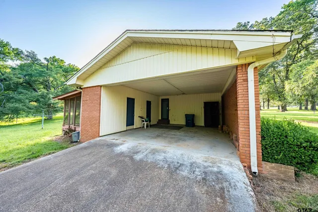 a backyard of a house with table and chairs plants and large tree