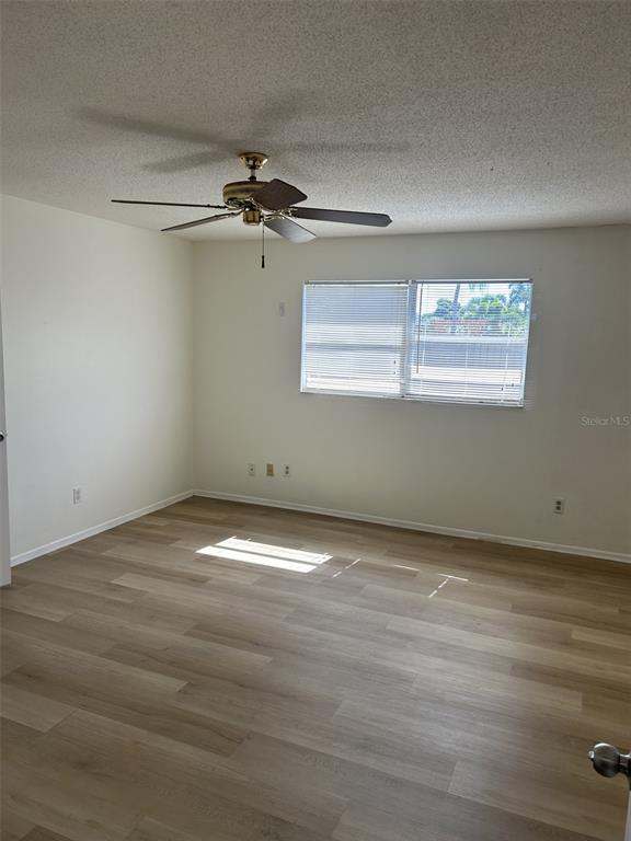 8873 Tami Street Seminole, FL 33772 - Photo 15 of 26 an empty room with wooden floor ceiling fan and windows