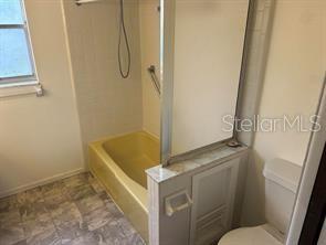 8873 Tami Street Seminole, FL 33772 - Photo 22 of 26 a bathroom with a granite countertop sink a toilet and a shower