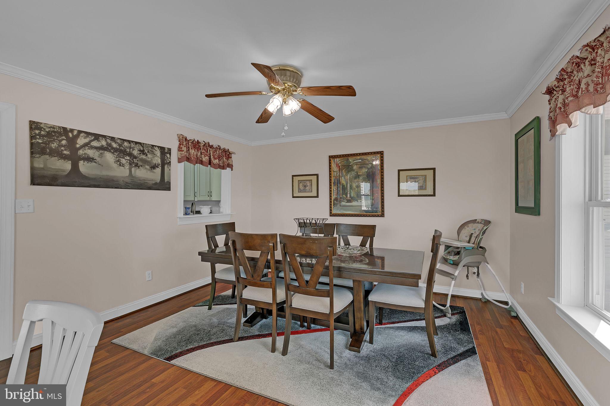 1887 Point Breeze Road Hudgins, VA 23076 - Photo 58 of 77 a dining room with wooden floor and a chandelier fan