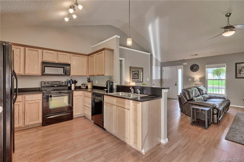 13314 Philip Michael Road Huntersville, NC 28078 - Photo 12 of 39 a kitchen with stainless steel appliances kitchen island granite countertop a stove top oven a sink dishwasher a dining table and chairs with wooden floor