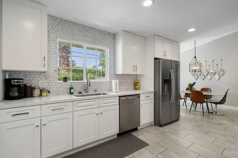 a kitchen with stainless steel appliances a refrigerator sink and cabinets