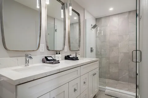 a bathroom with double sink and a mirror