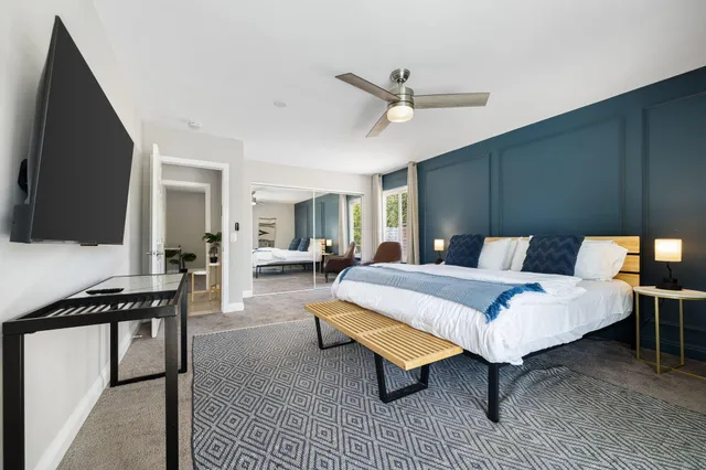 a spacious bedroom with a bed and a flat screen tv