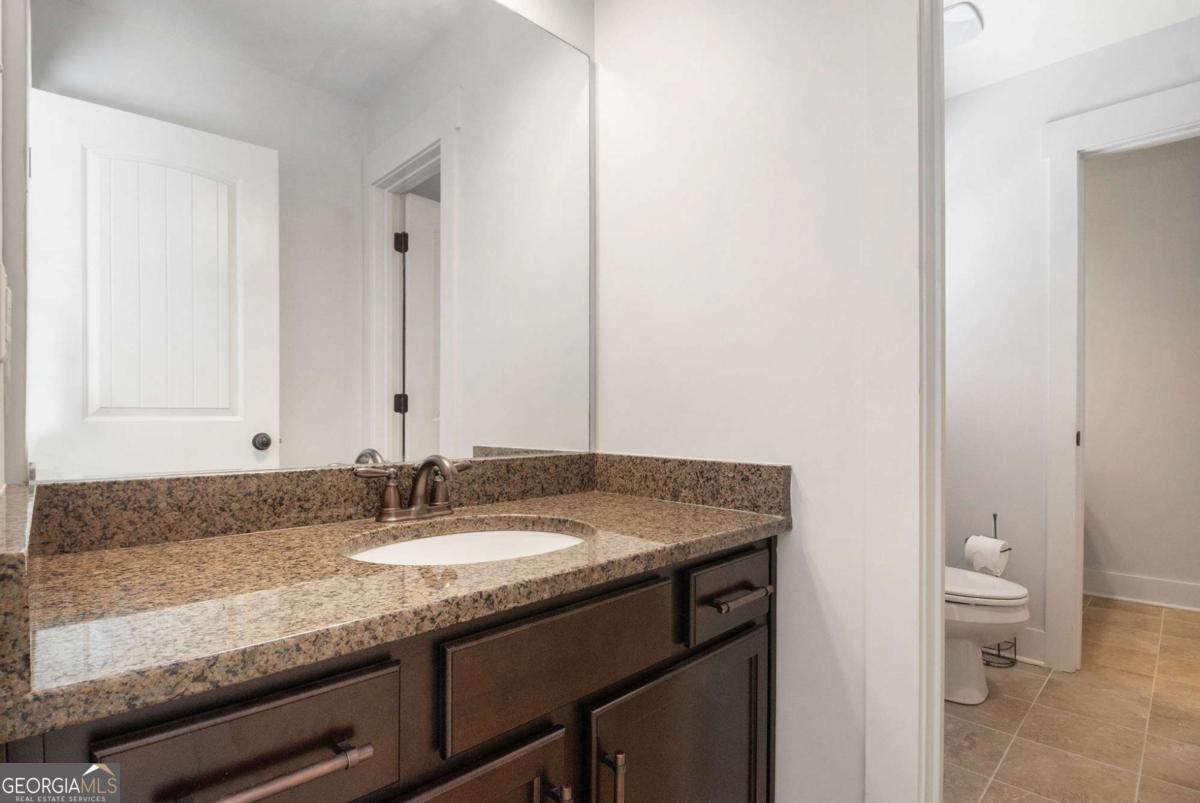 466 Austin Storey Circle Newnan, GA 30263 - Photo 18 of 39 a bathroom with a granite countertop sink and a mirror