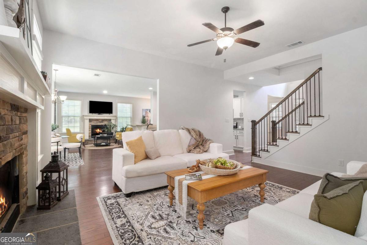 466 Austin Storey Circle Newnan, GA 30263 - Photo 2 of 39 a living room with furniture a fireplace and a chandelier
