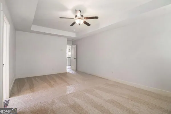 an empty room with a ceiling fan and a window
