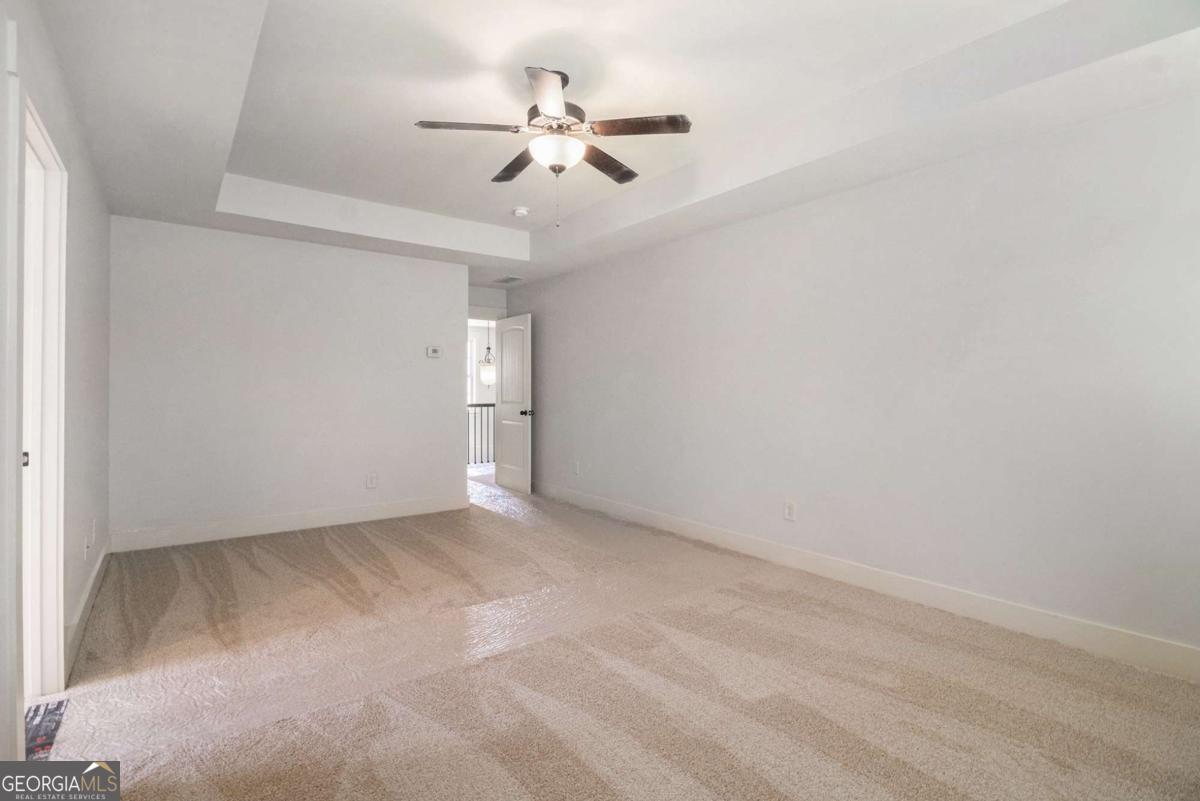 466 Austin Storey Circle Newnan, GA 30263 - Photo 21 of 39 an empty room with a ceiling fan and a window