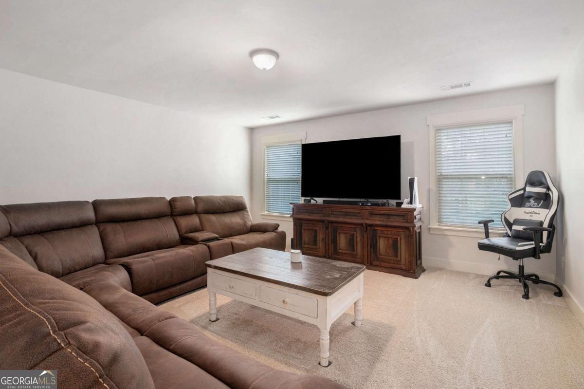 466 Austin Storey Circle Newnan, GA 30263 - Photo 27 of 39 a living room with furniture and a flat screen tv