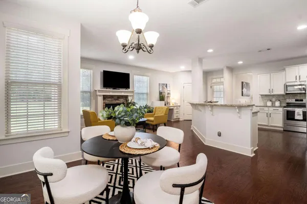a view of a dining room with furniture a chandelier and wooden floor