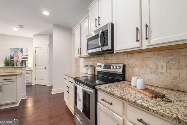 a kitchen with stainless steel appliances granite countertop a stove a sink and a microwave