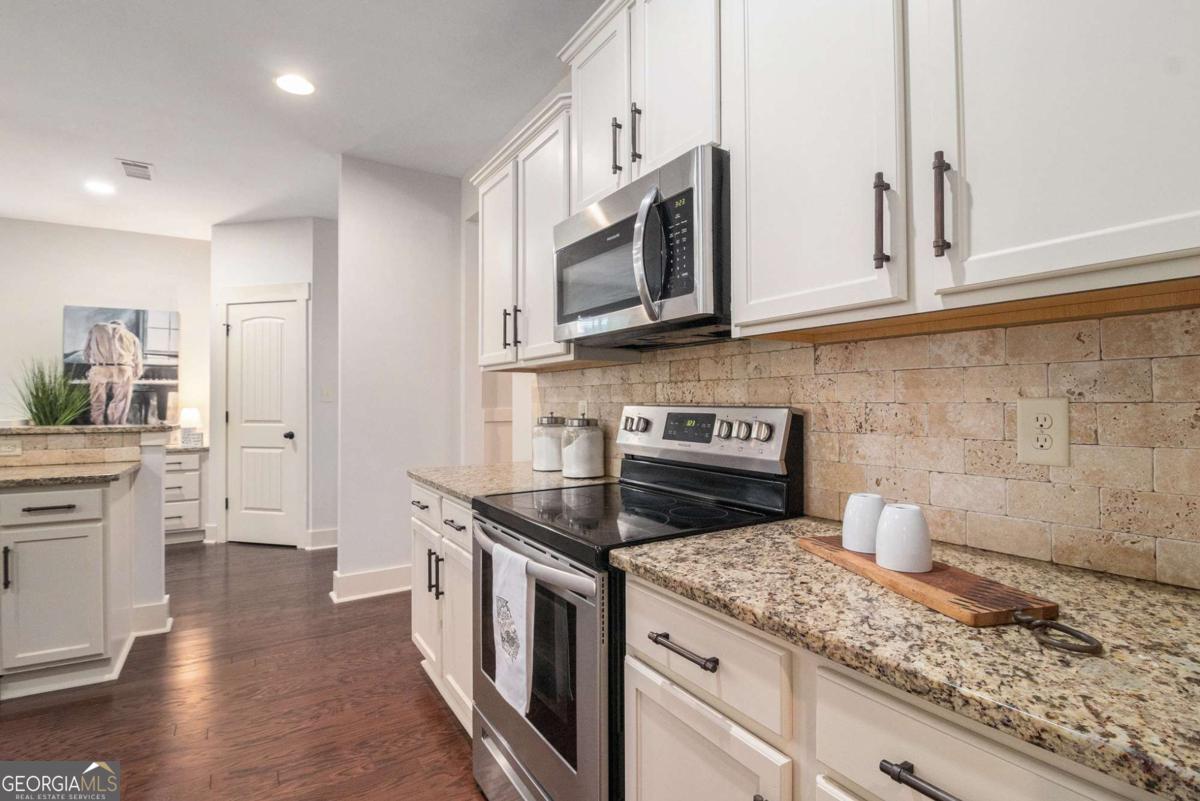 466 Austin Storey Circle Newnan, GA 30263 - Photo 10 of 39 a kitchen with stainless steel appliances granite countertop a stove a sink and a microwave