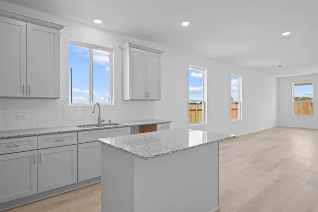 a kitchen with granite countertop white cabinets and white appliances
