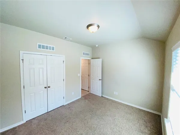 an empty room with an entryway and closet
