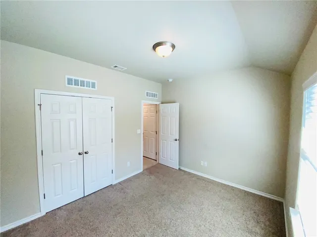 an empty room with an entryway and closet