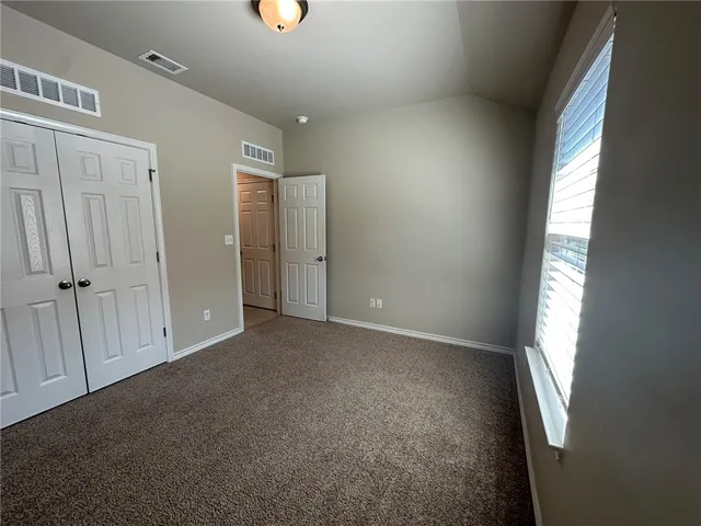 an empty room with windows and closet