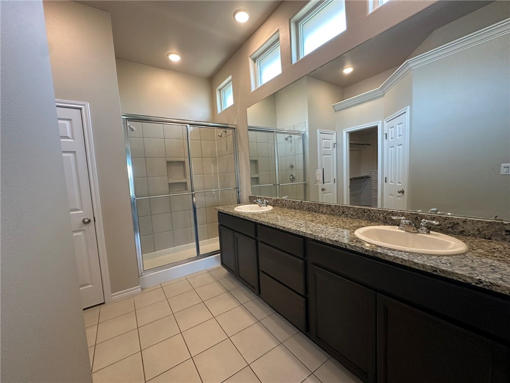 2270 Tallow Drive Portland, TX 78374 - Photo 26 of 38 a spacious bathroom with a granite countertop sink a mirror and a shower